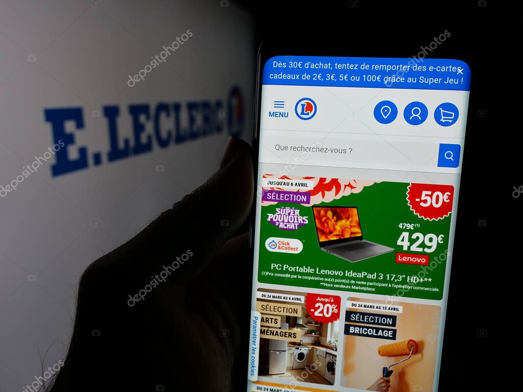 Stuttgart, Germany - 03-24-2025: Person holding web page with logo of French retail company E.Leclerc on screen in front of logo. Focus on center of phone display.