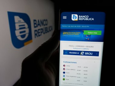 Stuttgart, Almanya - 04-01-2025: Logo önünde Uruguay şirketi Banco Republica 'nın (BROU) logosunun olduğu web sayfası bulunan kişi. Telefon ekranının merkezine odaklan.