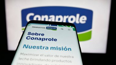 Stuttgart, Almanya - 04-01-2025: Web sitesinin önünde ekranda Uruguay süt ürünleri kooperatifi logosu olan cep telefonu. Telefon ekranının sol üst kısmına odaklan.