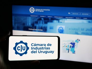 Stuttgart, Almanya - 04-02-2025: İnternet sitesi önünde ekranda Camara de Industrias del Uruguay adlı organizasyon logosuna sahip kişi görülüyor. Telefon ekranına odaklan.