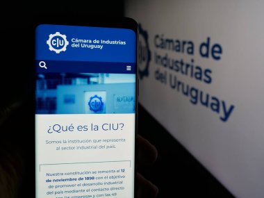 Stuttgart, Almanya - 04-02-2025: Organizasyon Camara de Industrias del Uruguay web sitesi ile cep telefonu tutan kişi logonun önünde ekranda. Telefon ekranının merkezine odaklan.