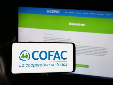 Stuttgart, Almanya - 04-02-2025: Web sitesi önünde Uruguaylı mali kooperatif COFAC logosu olan akıllı telefon sahibi kişi. Telefon ekranına odaklan.