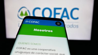 Stuttgart, Almanya - 04-02-2025: Web sitesi önünde ekranda Uruguaylı finansal kooperatif COFAC logosu olan cep telefonu. Telefon ekranının sol üst kısmına odaklan.