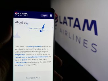 Stuttgart, Almanya - 04-03-2025: Havayolu şirketi LATAM Airlines Chile 'in internet sayfası ile cep telefonu tutan kişi logonun önünde ekranda. Telefon ekranının merkezine odaklan.