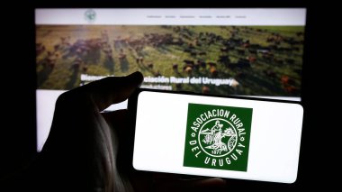 Stuttgart, Almanya - 04-03-2025: Web sayfasının önünde Asociacion Taşralı del Uruguay (ARU) logosu olan cep telefonu sahibi kişi. Telefon ekranına odaklan.