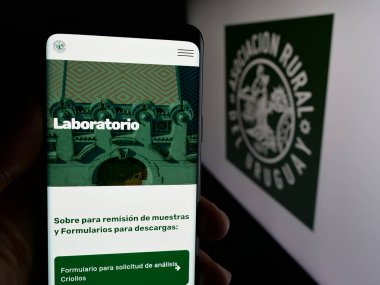 Stuttgart, Almanya - 04-03-2025: Logonun önünde Asociacion Rural del Uruguay (ARU) web sayfası bulunan kişi. Telefon ekranının merkezine odaklan.