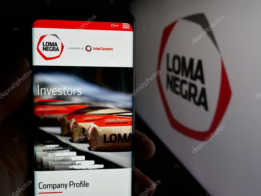 Stuttgart, Germany - 03-31-2025: Person holding cellphone with webpage of Loma Negra Compania Industrial Argentina S.A. on screen in front of logo. Focus on center of phone display.