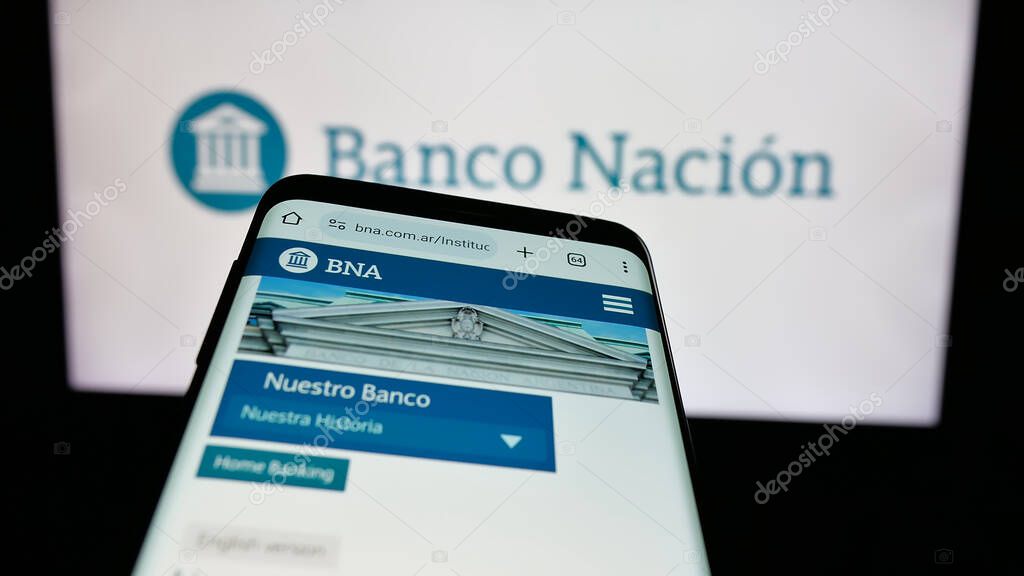 Stuttgart, Germany - 03-31-2025: Mobile phone with logo of company Banco de la Nacion Argentina (BNA) on screen in front of website. Focus on top-left of phone display.