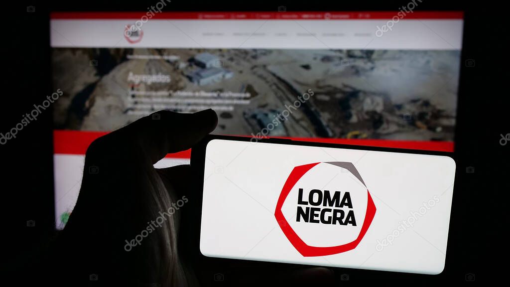Stuttgart, Germany - 03-31-2025: Person holding mobile phone with logo of Loma Negra Compania Industrial Argentina S.A. on screen in front of web page. Focus on phone display.