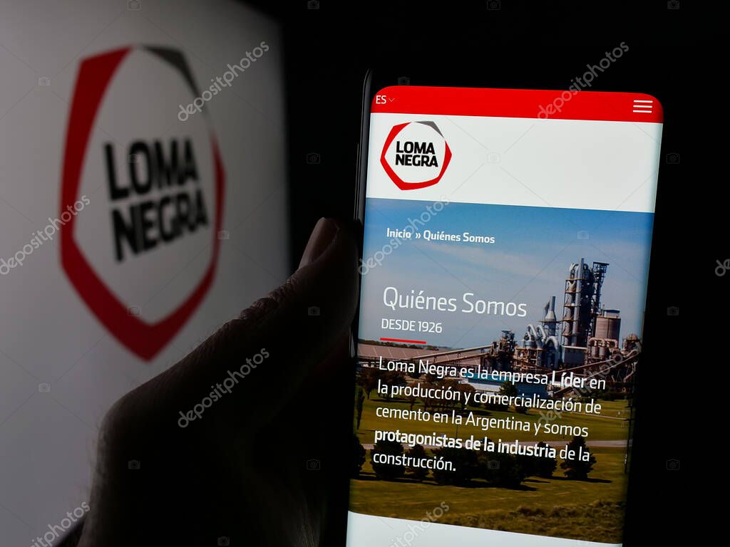 Stuttgart, Germany - 03-31-2025: Person holding web page with logo of Loma Negra Compania Industrial Argentina S.A. on screen in front of logo. Focus on center of phone display.