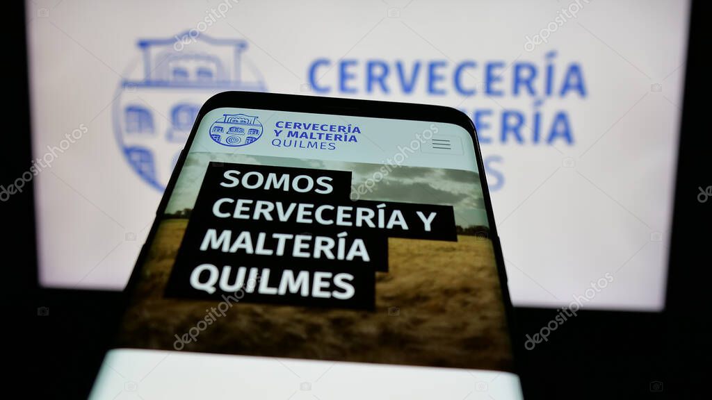 Stuttgart, Germany - 04-01-2025: Mobile phone with logo of brewing company Cerveceria y Malteria Quilmes on screen in front of website. Focus on top-left of phone display.