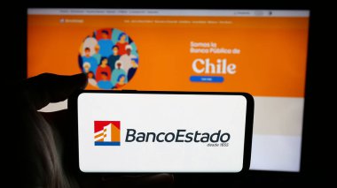 Stuttgart, Almanya - 04-03-2025: Web sayfası önünde üzerinde Banco del Estado (BancoEstado de Chile) logosu olan cep telefonu sahibi kişi. Telefon ekranına odaklan.