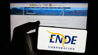 Stuttgart, Almanya - 04-03-2025: Web sayfasının önünde ekranda Empresa Nacional de Electricidad (ENDE) logosu bulunan cep telefonu sahibi kişi. Telefon ekranına odaklan.