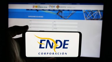 Stuttgart, Almanya - 04-03-2025: Web sayfası önünde Empresa Nacional de Electricidad (ENDE) logosunun bulunduğu cep telefonu sahibi kişi. Telefon ekranına odaklan.