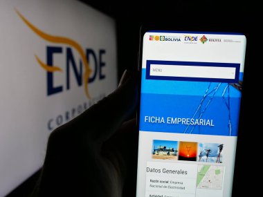 Stuttgart, Almanya - 04-03-2025: Logonun önündeki ekranda Empresa Nacional de Electricidad (ENDE) logosunun logosu bulunan kişi. Telefon ekranının merkezine odaklan.