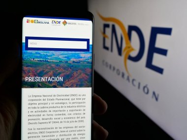 Stuttgart, Almanya - 04-03-2025: Logo önündeki ekranda Empresa Nacional de Electricidad (ENDE) web sayfası bulunan kişi. Telefon ekranının merkezine odaklan.