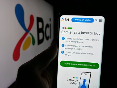 Stuttgart, Almanya - 04-03-2025: Logonun önündeki ekranda Banco de Credito e Inversiones S.A. (BCI) logosunun logosu bulunan kişi. Telefon ekranının merkezine odaklan.