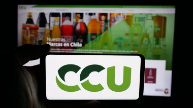 Stuttgart, Almanya - 04-03-2025: İnternet sayfası önünde Compania Cervecerias Unidas S.A. (CCU) logosu olan cep telefonu sahibi kişi. Telefon ekranına odaklan.