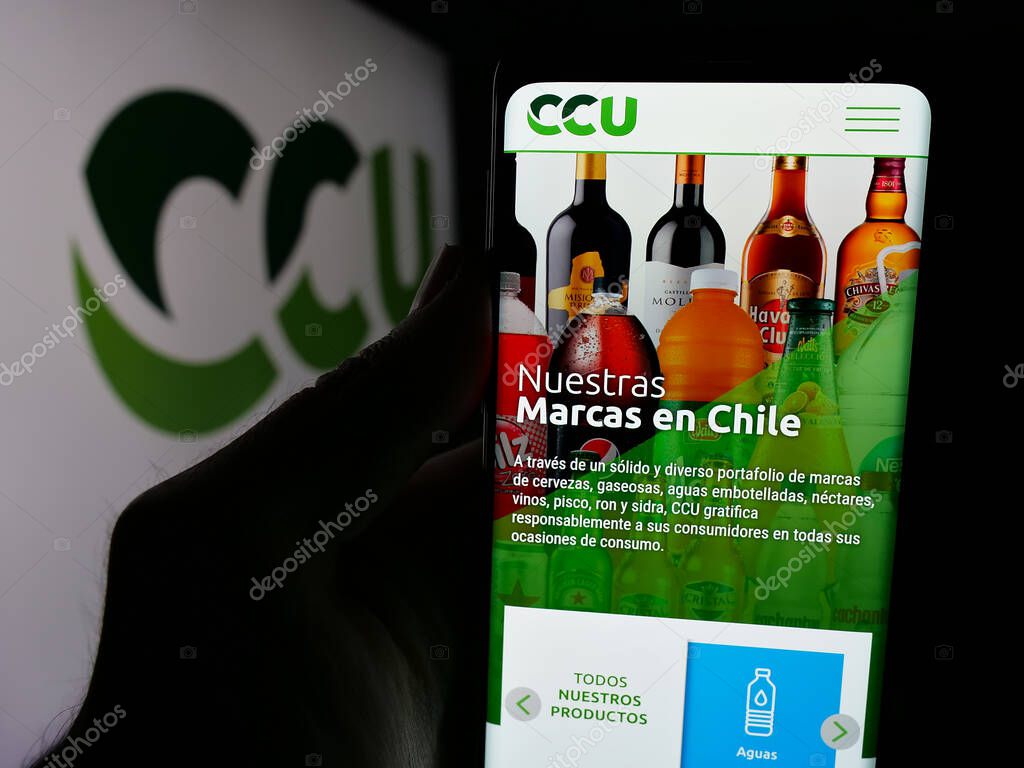 Stuttgart, Germany - 04-03-2025: Person holding web page with logo of Compania Cervecerias Unidas S.A. (CCU) on screen in front of logo. Focus on center of phone display.