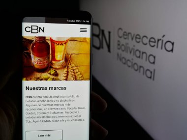 Stuttgart, Almanya - 04-07-2025: Logo önündeki ekranda Cerveceria Boliviana Nacional (CBN) şirketinin internet sayfası bulunan kişi. Telefon ekranının merkezine odaklan.