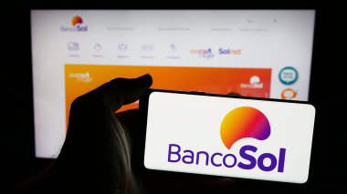 Stuttgart, Almanya - 04-07-2025: İnternet sayfası önünde üzerinde Banco Solidario S.A. (BancoSol) logosu bulunan cep telefonu sahibi kişi. Telefon ekranına odaklan.