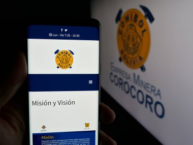 Stuttgart, Almanya - 04-07-2025: Logo önünde ekranda Empresa Minera Corocoro (COMIBOL) şirketinin web sayfası bulunan kişi. Telefon ekranının merkezine odaklan.