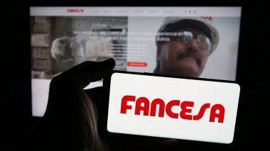 Stuttgart, Almanya - 04-09-2025: İnternet sayfasının önünde Fabrica Nacional de Cemento (FANCESA) şirketinin logosunun bulunduğu cep telefonu sahibi kişi. Telefon ekranına odaklan.