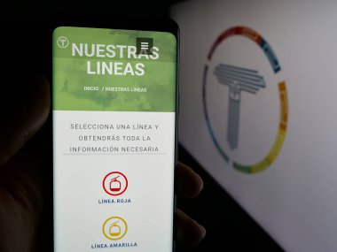 Stuttgart, Almanya - 04-09-2025: Bolivyalı teleferik şirketi Mi Teleferico 'nun internet sayfası ile logo önünde cep telefonu tutan kişi. Telefon ekranının merkezine odaklan.