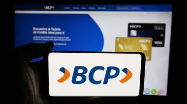 Stuttgart, Almanya - 04-09-2025: İnternet sayfası önünde üzerinde Banco de Credito de Bolivia S.A. (BCP) logosu bulunan kişi. Telefon ekranına odaklan.