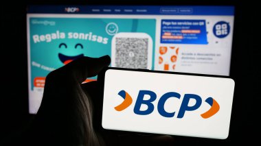 Stuttgart, Almanya - 04-09-2025: İnternet sayfasının önünde üzerinde Banco de Credito de Bolivia S.A. (BCP) logosu bulunan cep telefonu sahibi kişi. Telefon ekranına odaklan.