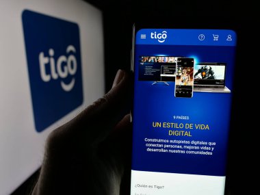 Stuttgart, Almanya - 04-09-2025: Telekomünikasyon şirketi Tigo Bolivya 'nın internet sayfası olan cep telefonu logosu önünde ekranda. Telefon ekranının merkezine odaklan.