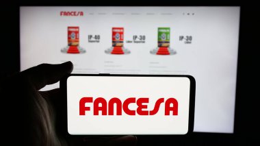 Stuttgart, Almanya - 04-09-2025: İnternet sayfası önünde Fabrica Nacional de Cemento (FANCESA) şirketinin logosunun bulunduğu cep telefonu sahibi kişi. Telefon ekranına odaklan.