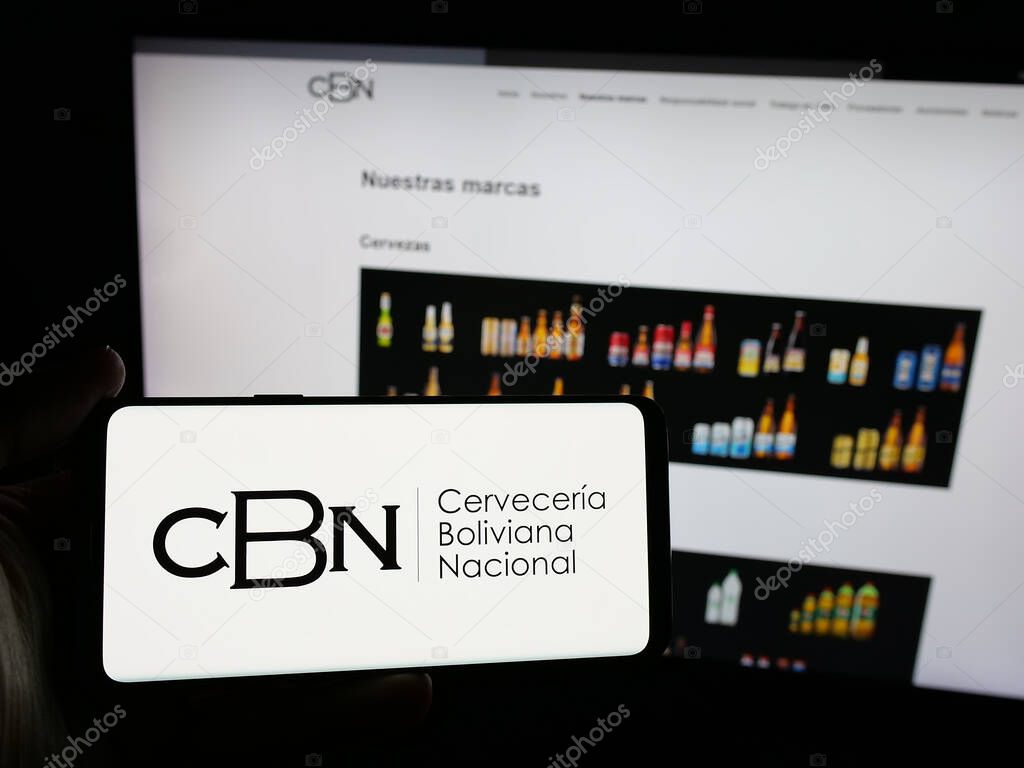 Stuttgart, Germany - 04-07-2025: Person holding smartphone with logo of company Cerveceria Boliviana Nacional (CBN) on screen in front of website. Focus on phone display.