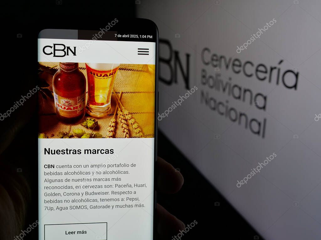 Stuttgart, Germany - 04-07-2025: Person holding cellphone with webpage of company Cerveceria Boliviana Nacional (CBN) on screen in front of logo. Focus on center of phone display.