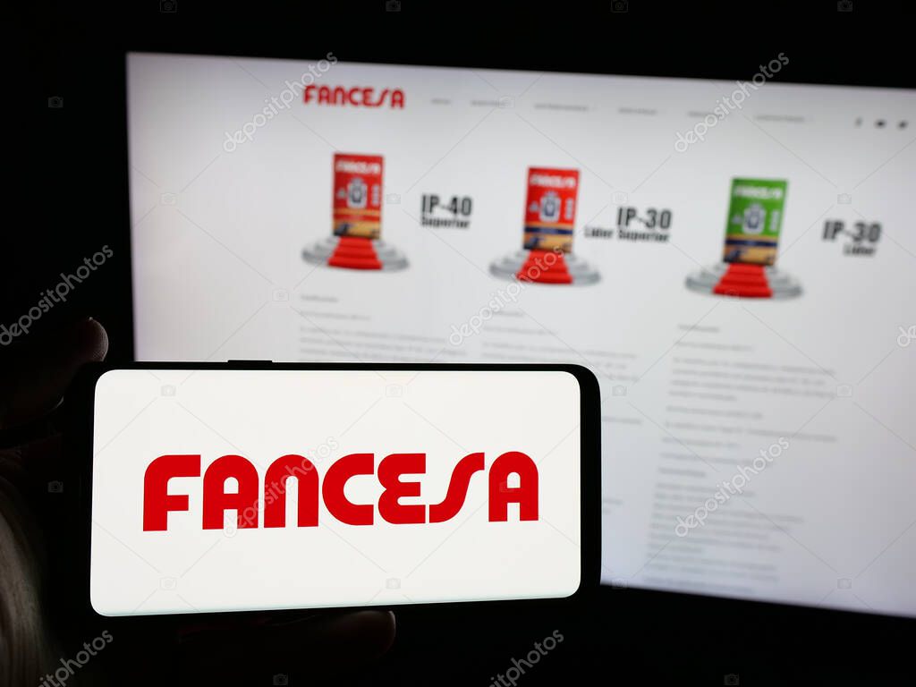 Stuttgart, Germany - 04-09-2025: Person holding smartphone with logo of company Fabrica Nacional de Cemento (FANCESA) on screen in front of website. Focus on phone display.