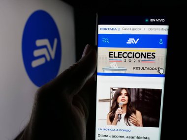 Stuttgart, Almanya - 04-09-2025: Ekvador televizyon kanalı Ecuavisa 'nın web sitesi ile logo önünde akıllı telefon tutan kişi. Telefon ekranının merkezine odaklan.