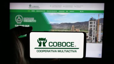 Stuttgart, Almanya - 04-09-2025: İnternet sayfasının önünde Cooperativa Boliviana de Cemento (COBOCE) logosu olan kişi. Telefon ekranına odaklan.