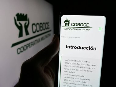 Stuttgart, Almanya - 04-09-2025: Kooperativa Boliviana de Cemento 'nun (COBOCE) web sitesi logonun önünde duran kişi. Telefon ekranının merkezine odaklan.