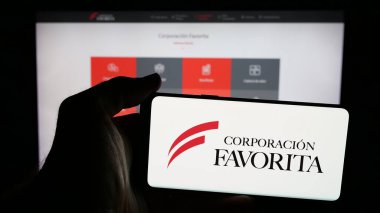 Stuttgart, Almanya - 04-09-2025: Perakende şirketi Favorita C.A. logosuna sahip cep telefonu sahibi kişi Web sayfasının önünde ekranda. Telefon ekranına odaklan.