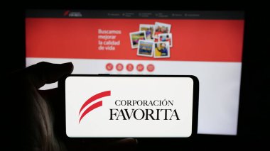 Stuttgart, Almanya - 04-09-2025: Perakende şirketi Favorita C.A. logosu olan kişi Web sayfasının önünde ekranda. Telefon ekranına odaklan.