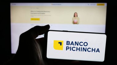 Stuttgart, Almanya - 04-09-2025: Finans şirketi Banco Pichincha C.A. logosuyla cep telefonu tutan kişi Web sayfasının önünde ekranda. Telefon ekranına odaklan.
