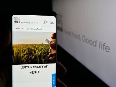 Stuttgart, Almanya - 04-09-2025: Cep telefonunda İsviçre yiyecek ve içecek şirketi Nestle S.A. 'nın web sayfası bulunan kişi logo önünde ekranda. Telefon ekranının merkezine odaklan.