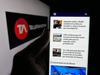 Stuttgart, Almanya - 04-09-2025: Ekvador televizyon kanalı Teleamazonas 'ın web sitesi ile logo önünde akıllı telefon tutan kişi. Telefon ekranının merkezine odaklan.