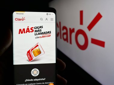 Stuttgart, Almanya - 04-09-2025: Telekomünikasyon şirketi Claro Ecuado 'nun web sayfası ile cep telefonu tutan kişi logonun önünde ekranda. Telefon ekranının merkezine odaklan.