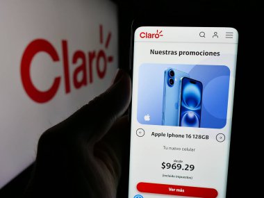 Stuttgart, Almanya - 04-09-2025: Telekomünikasyon şirketi Claro Ecuado 'nun web sitesi ile akıllı telefonu olan kişi logo önünde ekranda. Telefon ekranının merkezine odaklan.