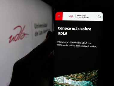 Stuttgart, Almanya - 04-09-2025: Üniversite Universidad de las Americas 'ın (UDLA) web sitesi olan kişi logonun önünde ekranda. Telefon ekranının merkezine odaklan.
