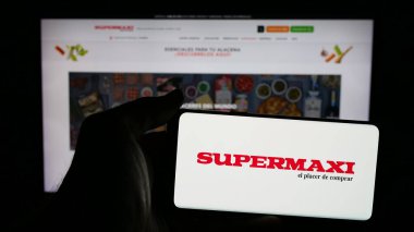 Stuttgart, Almanya - 04-09-2025: Ekvador perakende şirketi Supermaxi 'nin logosunun bulunduğu cep telefonu web sayfasının önünde duruyor. Telefon ekranına odaklan.