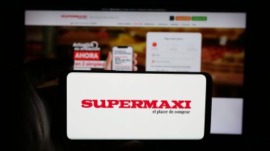 Stuttgart, Almanya - 04-09-2025: Ekvador perakende şirketi Supermaxi 'nin logosunun bulunduğu cep telefonu web sayfası önünde. Telefon ekranına odaklan.