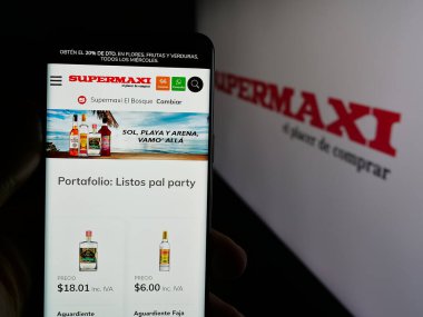 Stuttgart, Almanya - 04-09-2025: Ekvador perakende şirketi Supermaxi 'nin web sayfası olan cep telefonu logosu önünde ekranda. Telefon ekranının merkezine odaklan.