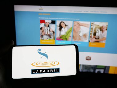 Stuttgart, Almanya - 04-09-2025: Ekvador 'lu gıda şirketi La Fabril S.A.' nın logosunu elinde tutan kişi web sitesinin önünde ekranda. Telefon ekranına odaklan.